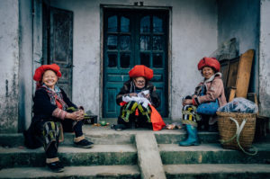 Thress Ta Phin - Red Dao ladies in front of a house with green door