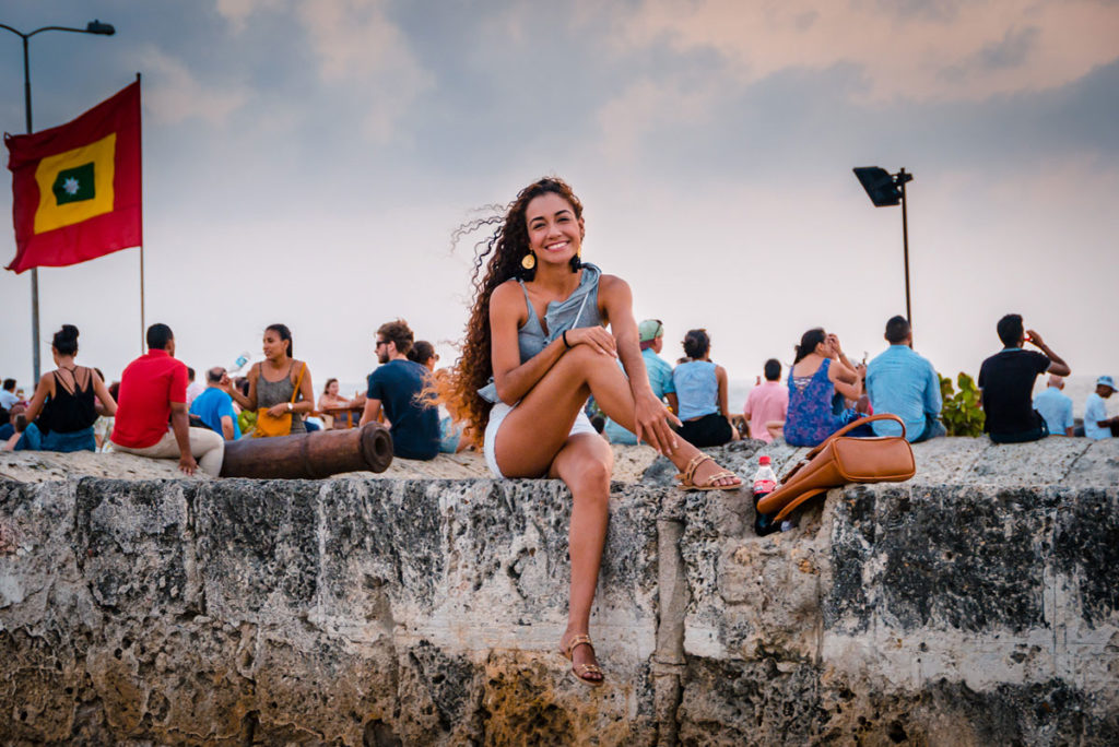Young woman sitting on top of a wall - Cartagena