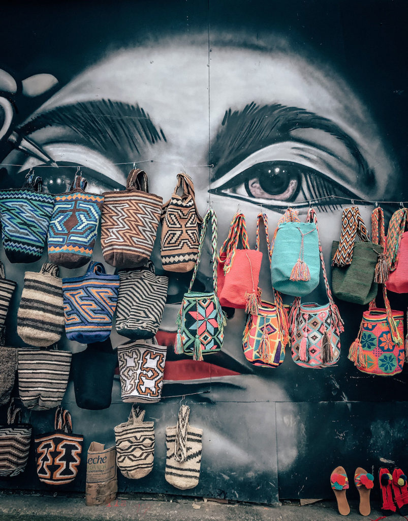 Graffiti of a woman covered in bags - Bogotá