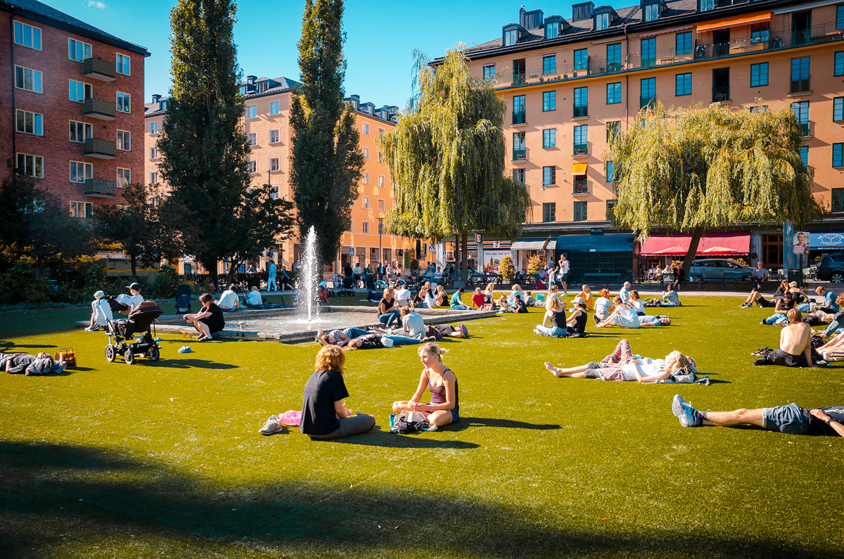 People relaxing around a fountain in Nytorget Park, Sweden