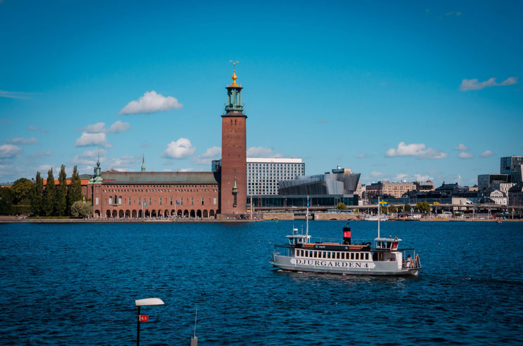 View of the lake outside the red-bricked City Hall building in Stockholm, Sweden