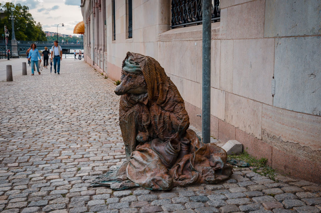 Statue of a fox with her baby both covered in blanket with a pair of boots