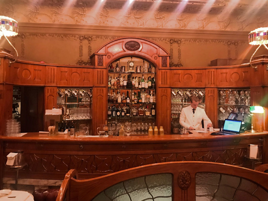 Bar attendant inside a beautifully adorned wine and liquor bar