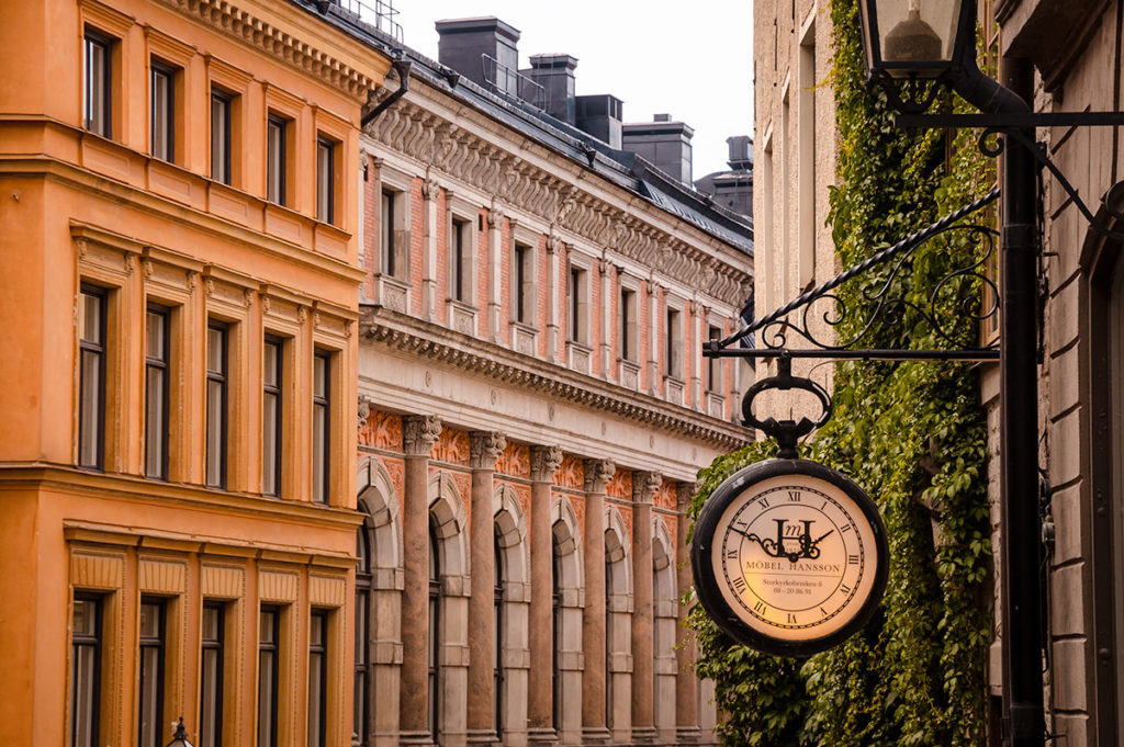 Outdoor numerals clock with row of buildings in the background