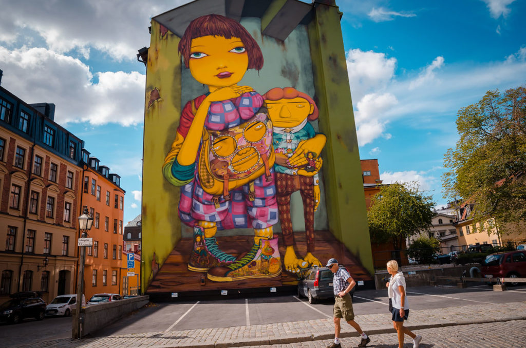 Huge, colorful mural of two kids in the street of Stockholm