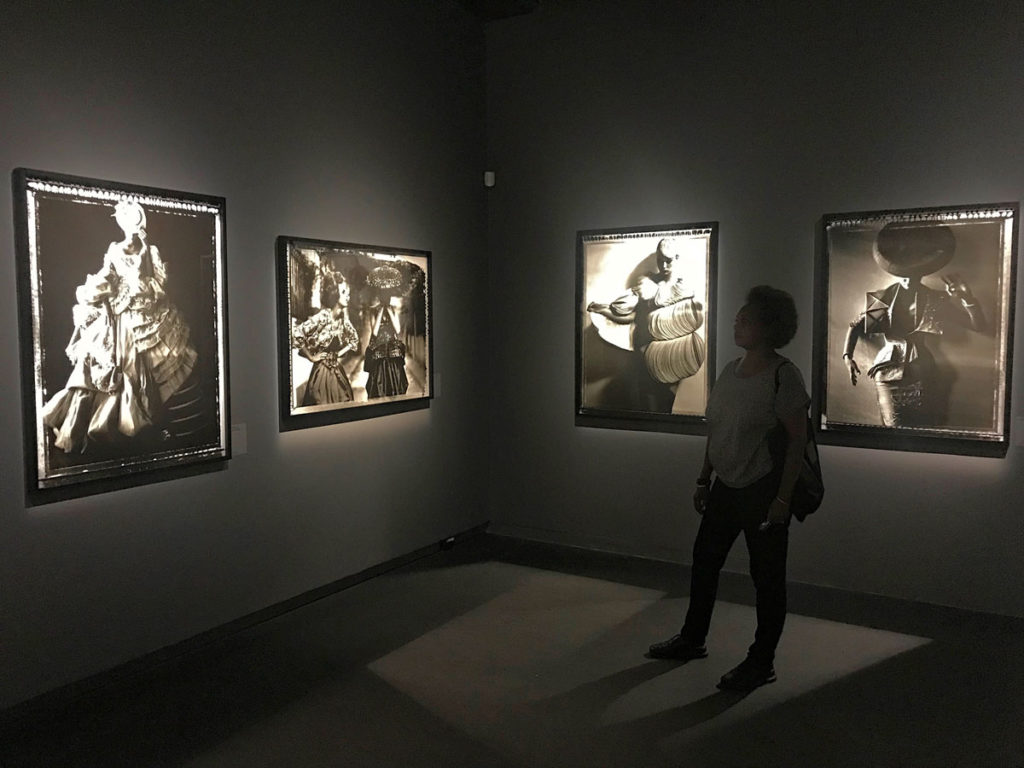 Khadija staring at black and white portraits in an exhibit