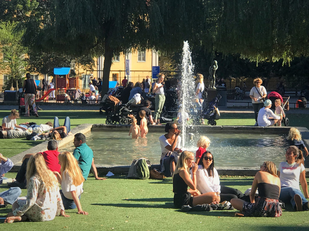 People relaxing around a small fountain in Nytorget Square
