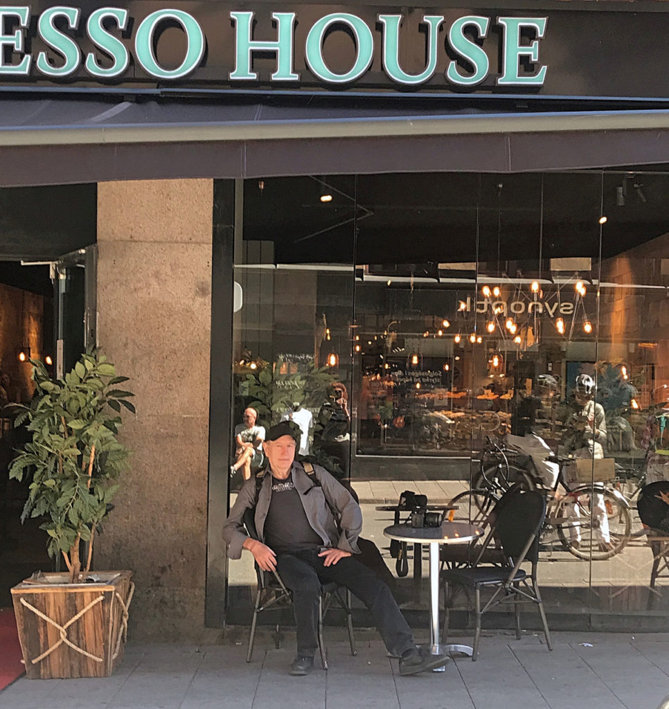 Ed sitting on a table outside a coffee shop