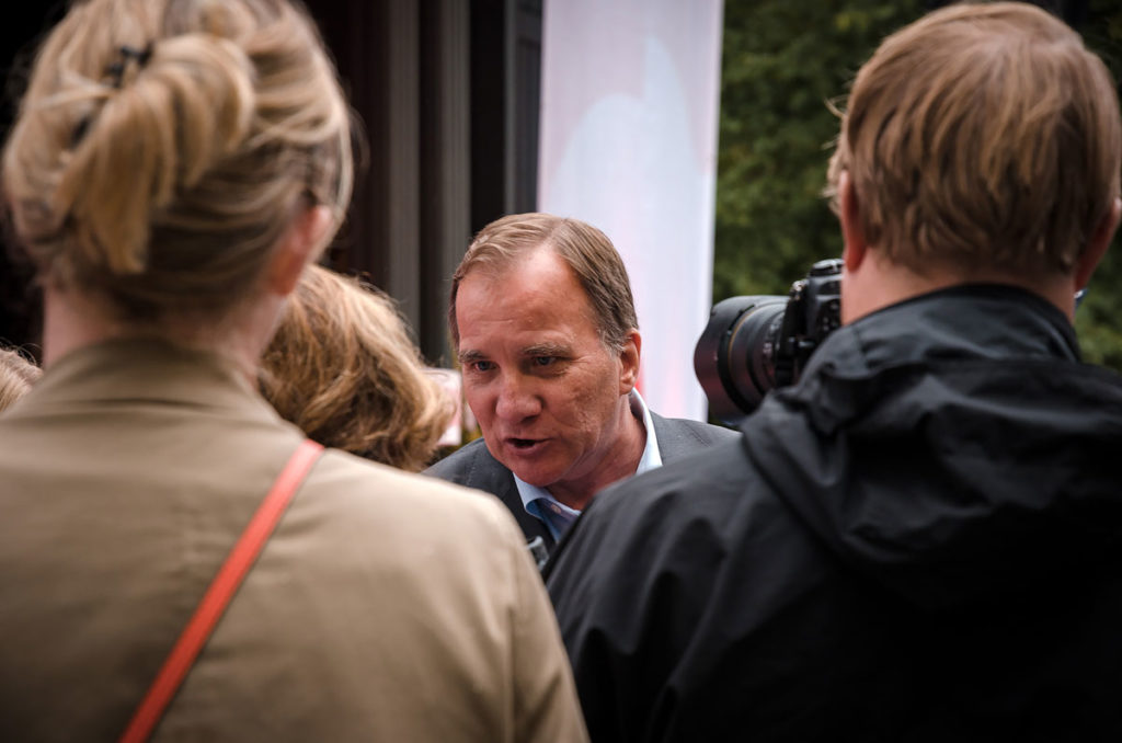Prime Minister Stefan Löfven talking to people from the press and photographers