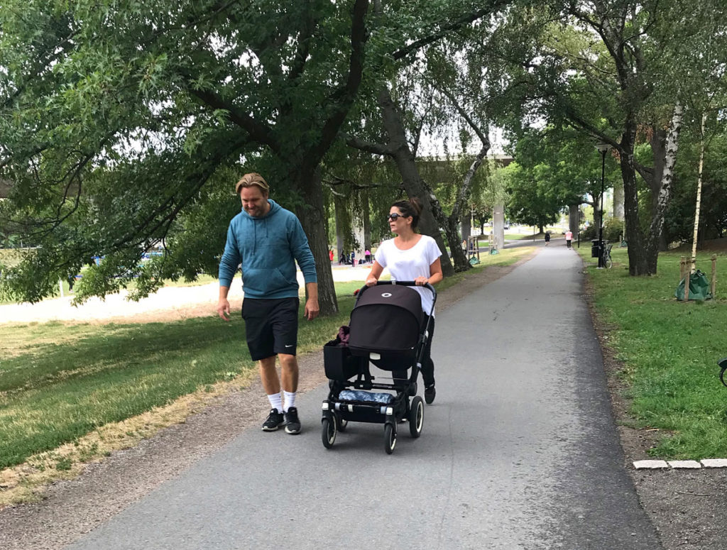 Couple walking with the baby on a stroller