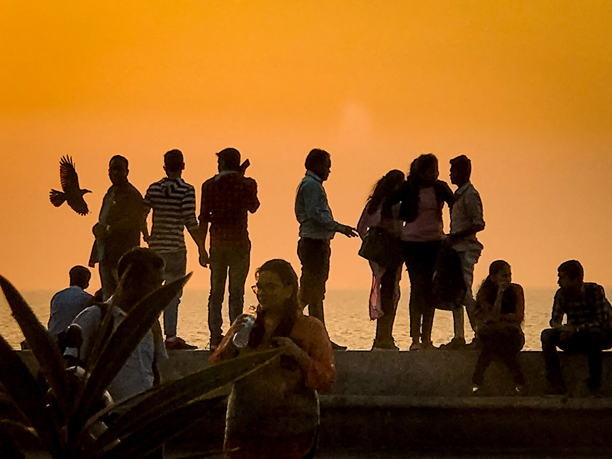 Group of young people in front of a sunset view - India