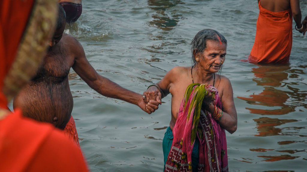 Elderly pilgrim couple bathing in the river - India