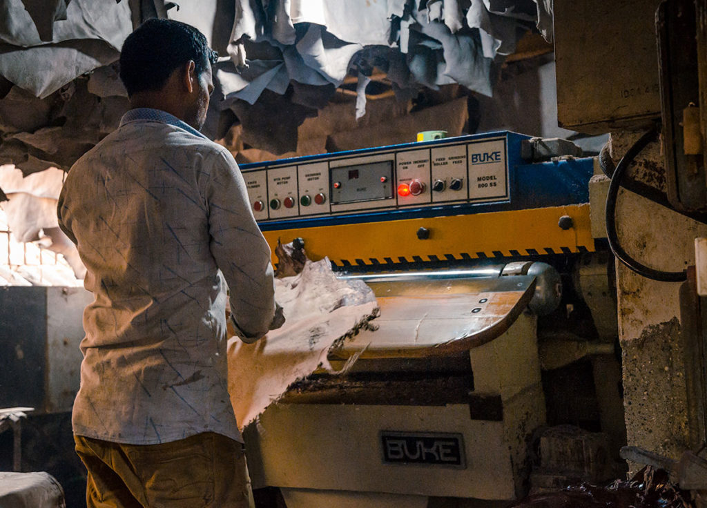 Man operating a leather-making machine - Dharavi