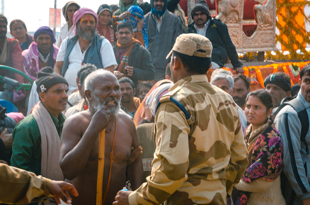 Crowd with agitated man facing an officer - India