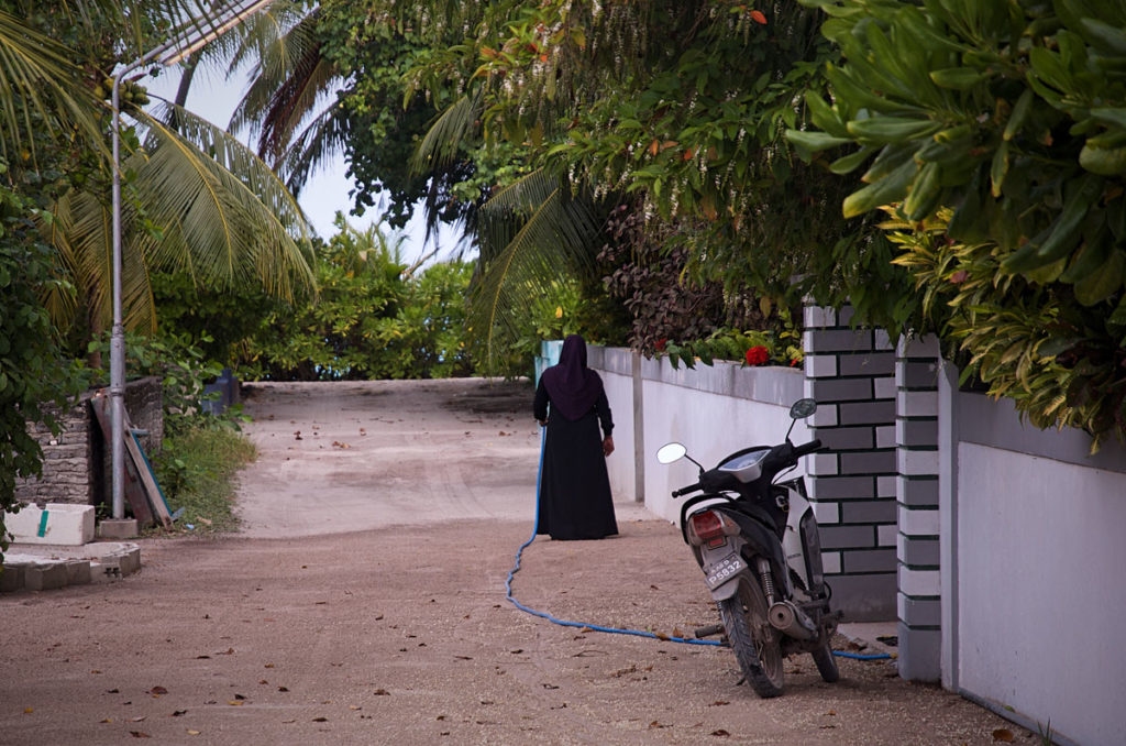 Woman watering her plants - Maldives