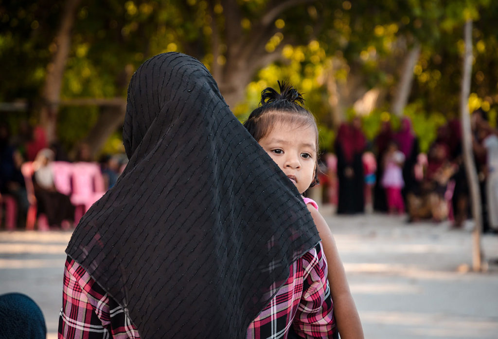 Mother carrying her young daughter - Dhigurah