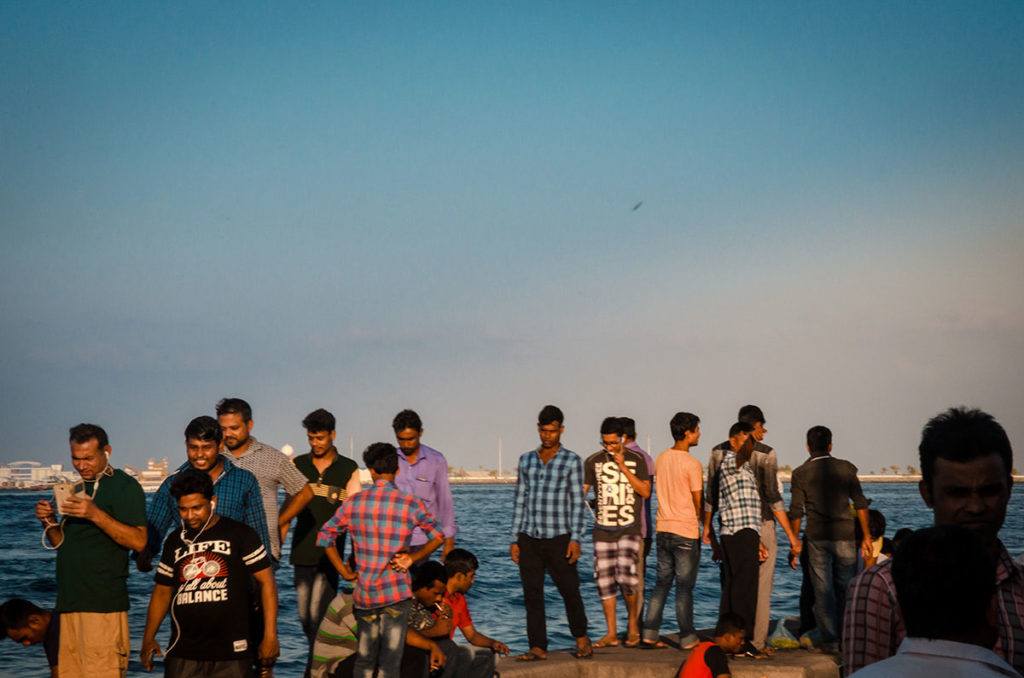 Men on a wall by the water - Malé