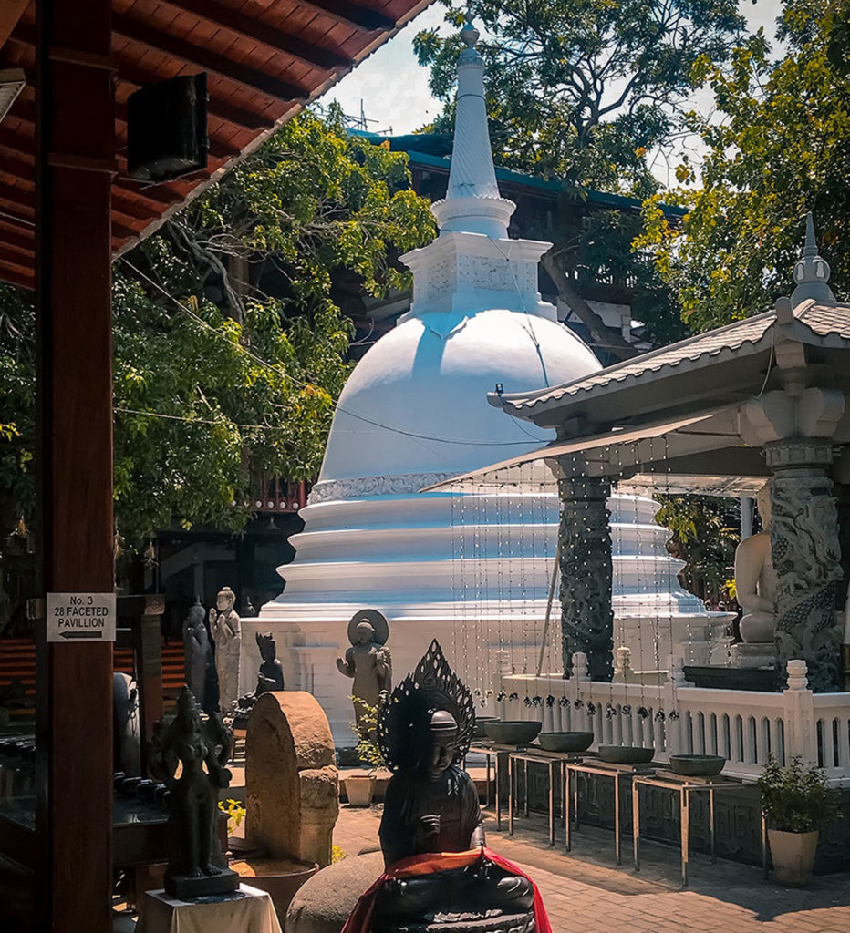 Statues around a white stupa - Gangaramaya Temple