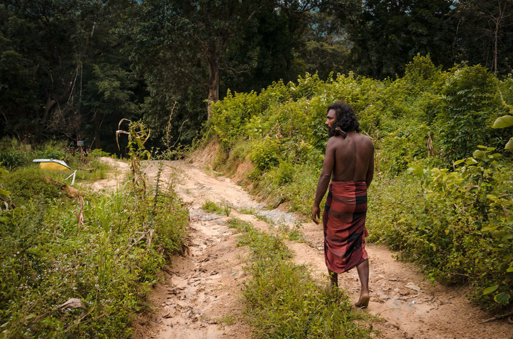 Vedda man walking on a dirt road - Sri Lanka