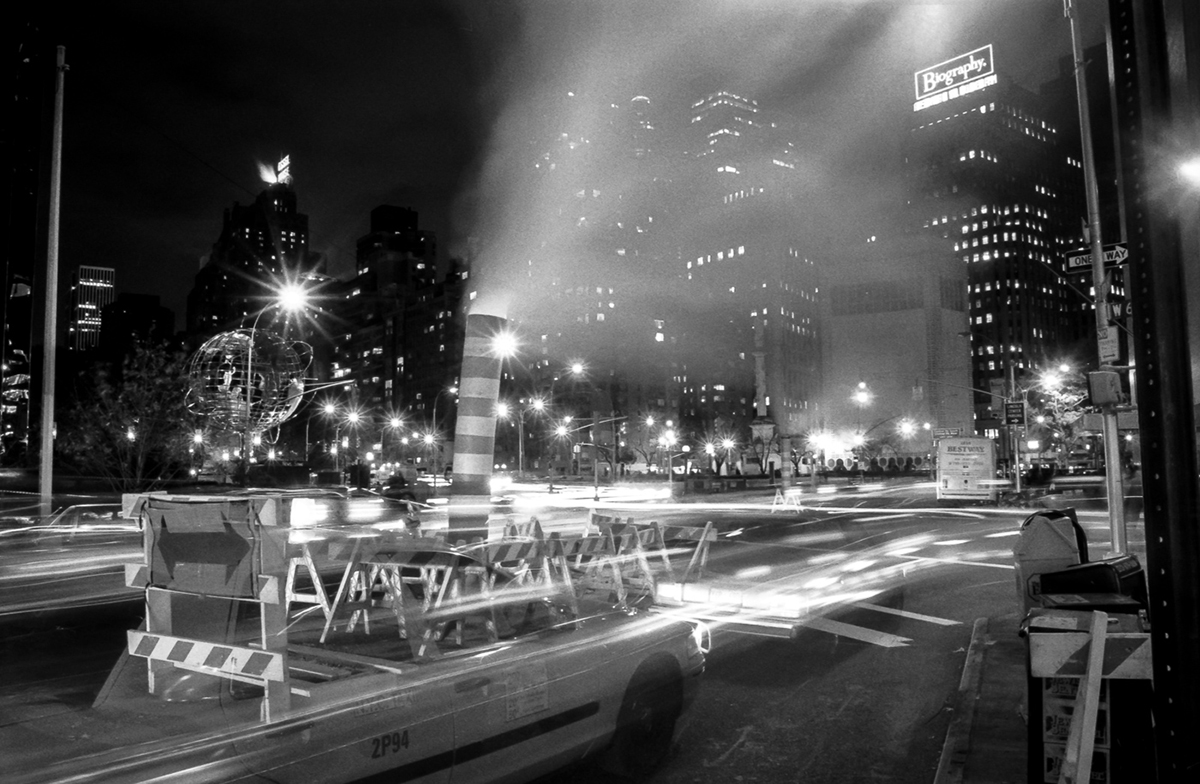 Ghost-like taxi passing by Columbus Circle at night