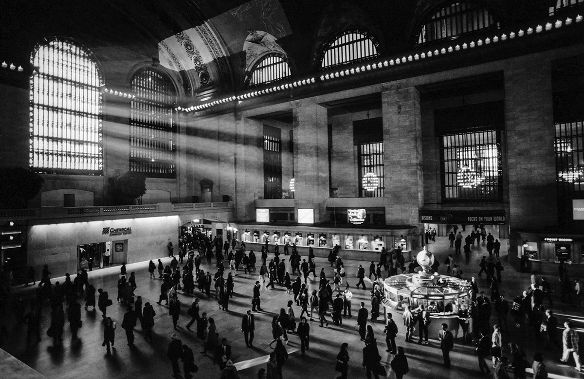 Commuters at Grand Central Station illuminated by the natural light from a huge window