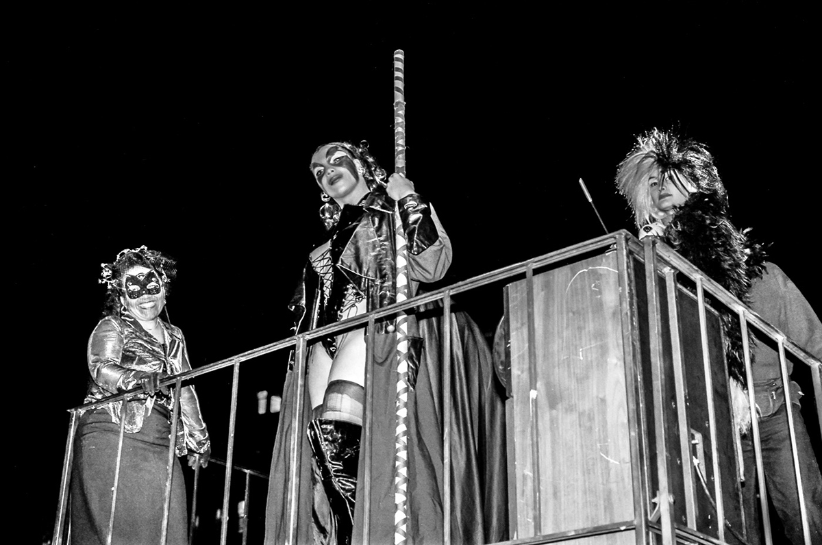 Three ladies on a balcony during a New York Halloween celebration