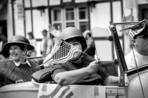 Lady veterans on a car waving a U.S flag